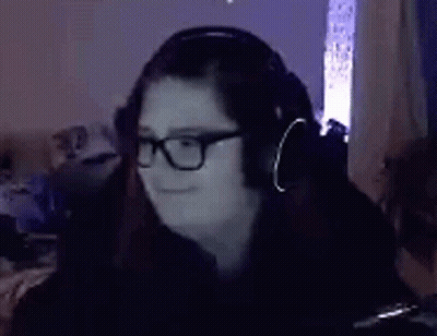Woman In Glasses And Headphones Sitting In Dark Room GIF