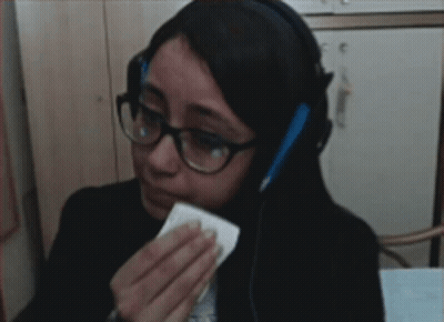 Woman In Glasses And Headphones Wiping Eyes With Tissue GIF