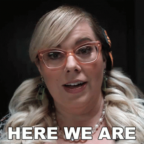 Woman In Glasses And Necklace Says Here We Are GIF