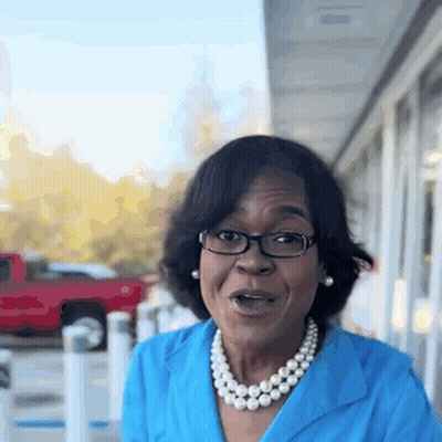 Woman In Glasses And Pearl Necklace By Red Truck GIF
