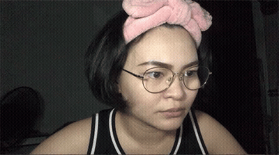 Woman In Glasses And Pink Headband Looking At Camera GIF