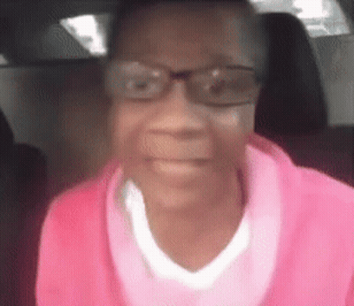 Woman In Glasses And Pink Sweater Sitting In Car GIF