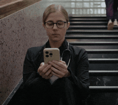 Woman In Glasses And Stethoscope Sitting On Stairs Looking At Phone GIF