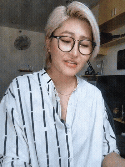 Woman In Glasses And Striped Shirt Looking Down GIF