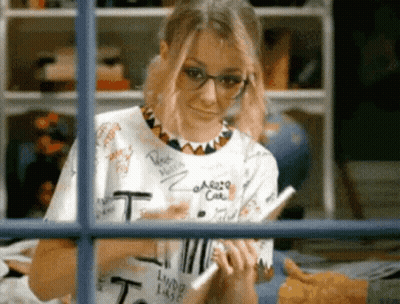 Woman In Glasses And T-Shirt Looking Out Window GIF