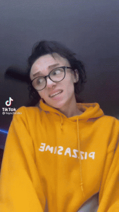 Woman In Glasses And Yellow Hoodie With TikTok Icon GIF