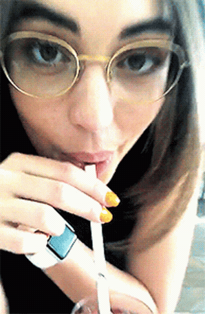 Woman In Glasses Drinking Through Straw GIF
