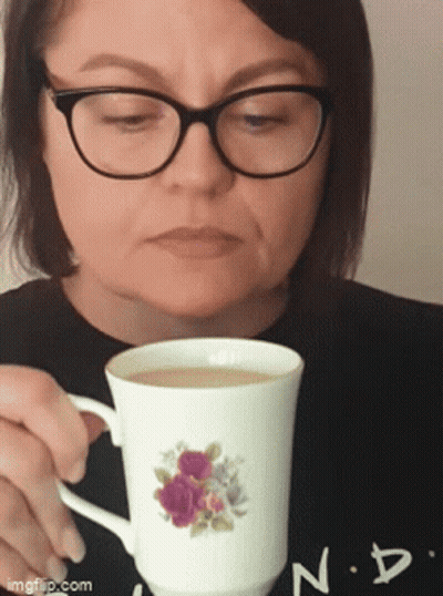 Woman In Glasses Holding Floral Coffee Cup GIF