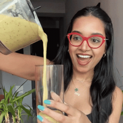 Woman in Glasses Pouring Smoothie Into Glass