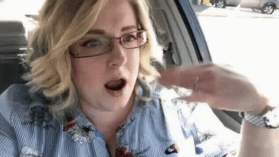 Woman In Glasses Sitting In Car Holding Water GIF