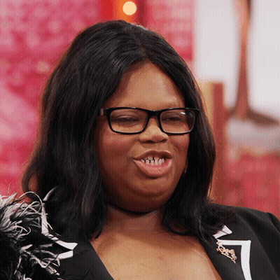 Woman In Glasses Smiling In Black Feather Jacket GIF