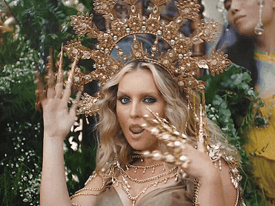 Woman In Gold Crown And Necklaces Making A Face GIF