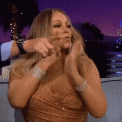 Woman In Gold Dress Sitting On Couch With Hands In Hair GIF