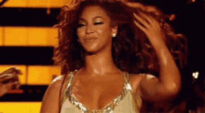 Woman In Gold Dress Touching Hair GIF