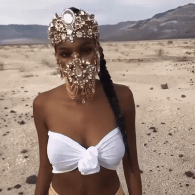 Woman In Gold Headpiece In Desert GIF
