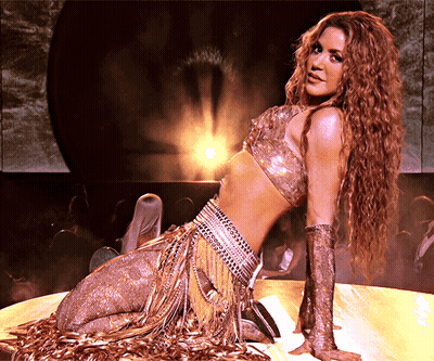 Woman In Gold Outfit Kneeling On Stage GIF