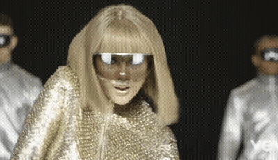 Woman In Gold Outfit With Mask And Sunglasses GIF