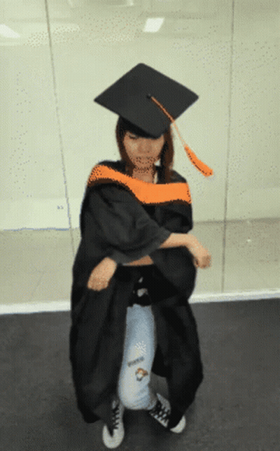 Woman In Graduation Cap And Gown Kneeling GIF