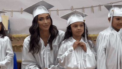 Woman In Graduation Cap And Gown Next To Girl GIF