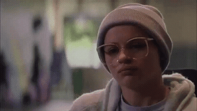 Woman In Gray Hoodie And White Sweatpants Under Gypsy Vinyl Sign GIF