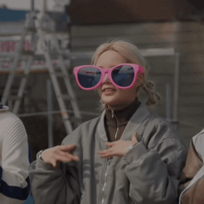 Woman In Gray Jacket And Pink Sunglasses Making Heart With Hands GIF