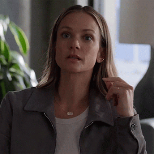 Woman In Gray Jacket And White Shirt Looks Surprised GIF