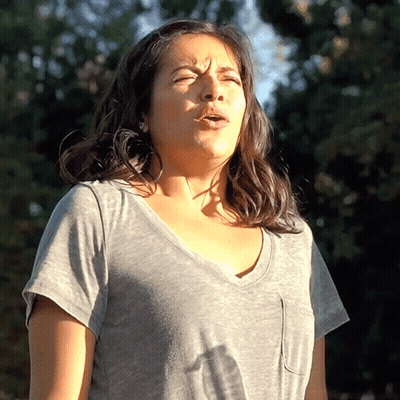 Woman In Gray Shirt With Eyes Closed GIF