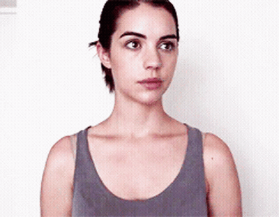 Woman In Gray Tank Top Looks At Camera GIF