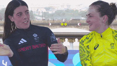 Woman In Great Britain Shirt Talks To Woman In Yellow Jacket GIF