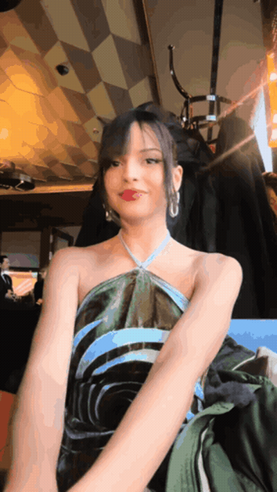 Woman In Green And Blue Dress Sitting In Chair GIF
