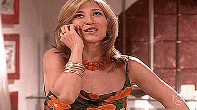 Woman In Green And Orange Floral Dress Talking On Phone GIF