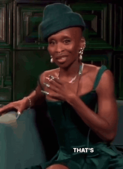 Woman In Green Dress And Green Hat On Couch GIF