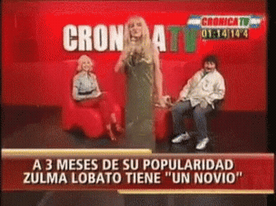Woman In Green Dress In Front Of Cronica TV Red Background GIF