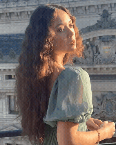 Woman In Green Dress Near Building With A Sign GIF