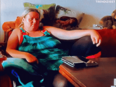 Woman In Green Dress Sitting On Couch With Legs Crossed GIF