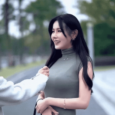 Woman In Green Dress Smiling With Arm Around Waist GIF