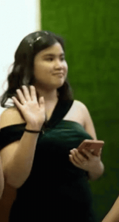 Woman In Green Dress Waving Holding Cell Phone GIF