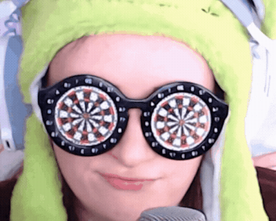 Woman In Green Hat And Sunglasses With Dart Board Eyes GIF
