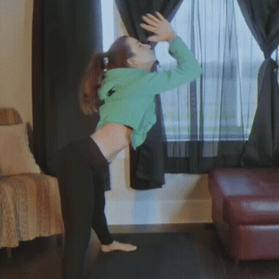 Woman In Green Hoodie And Black Pants At Window GIF