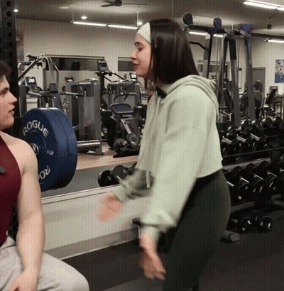Woman In Green Hoodie Talking To Man At Gym GIF