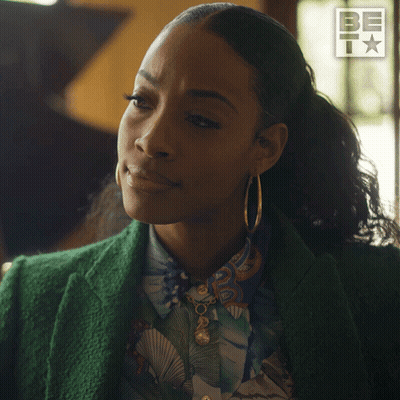 Woman In Green Jacket And Hoop Earrings Saying Sure GIF