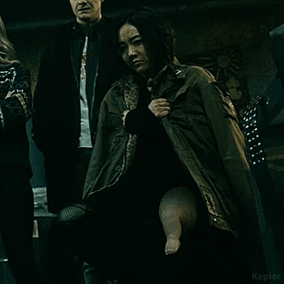 Woman In Green Jacket Holding Baby's Leg GIF