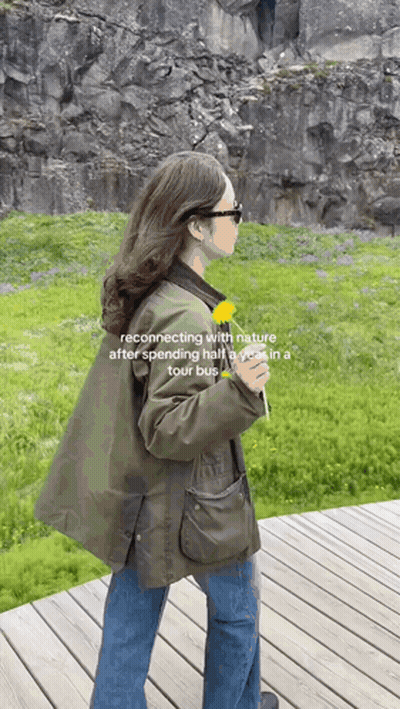 Woman In Green Jacket Holding Dandelion GIF
