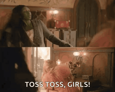 Woman In Green Mask Saying Toss Toss Girls Beside Pink Dress Girl GIF