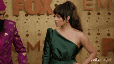 Woman In Green One-Shoulder Dress With Fox Sign GIF