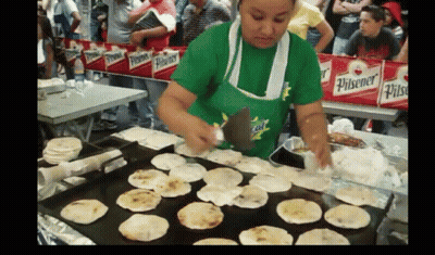 Woman In Green Pilsener Shirt Cooking GIF