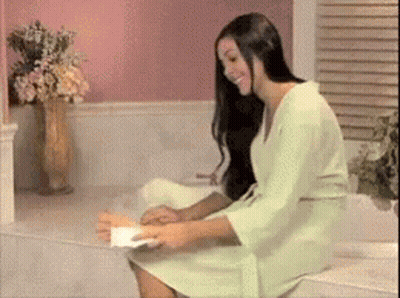 Woman In Green Robe Sitting In Bathtub Holding Paper GIF