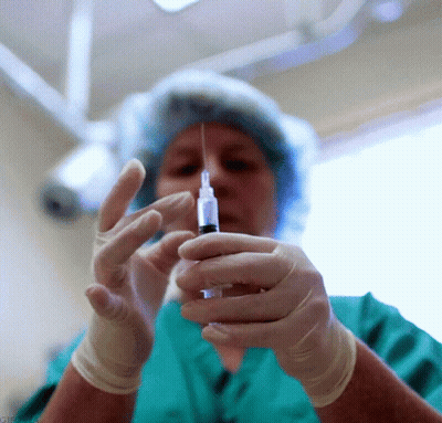 Woman In Green Scrubs Holding Syringe GIF