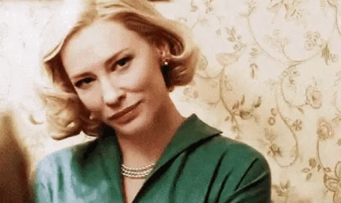Woman In Green Shirt And Pearl Necklace Making Funny Face GIF