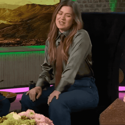 Woman In Green Shirt And Tie Sitting GIF